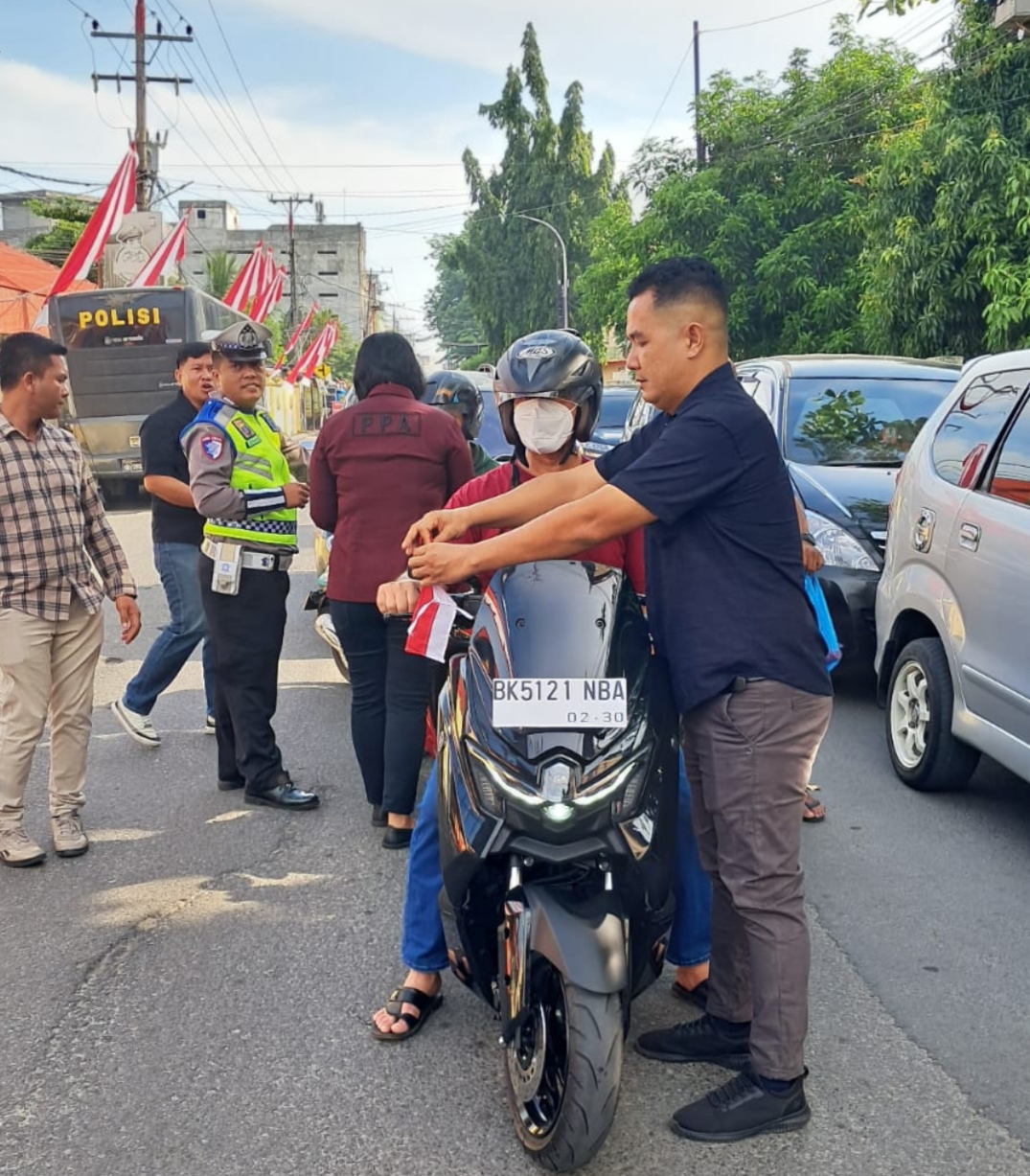 Kasat Reskrim Polres Tebing Tinggi Bagikan Bendera kepada Pengguna Jalan